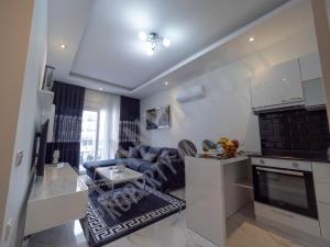uma cozinha e uma sala de estar com um sofá e uma mesa em Calypso Residence in Kestel Alanya E5 em Alanya