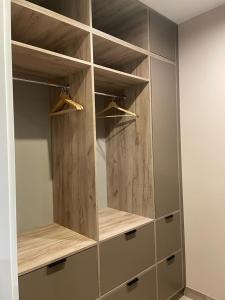 a closet with wooden shelves and cabinets in a room at GOLD Apartment Centrum garaż in Gliwice