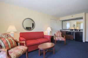 a living room with a red couch and a chair at Courtyard by Marriott Flint Grand Blanc in Flint