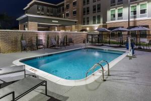 a large swimming pool with chairs and a building at Fairfield Inn & Suites Morganton Historic Downtown in Morganton