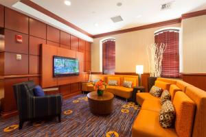 a waiting room with couches and a flat screen tv at Courtyard Boston Copley Square in Boston