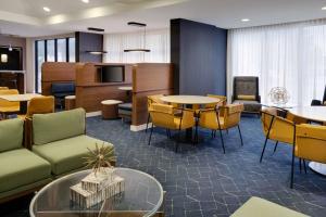 a lobby with tables and chairs and a living room at Courtyard Austin South in Austin
