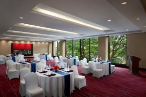 a banquet room with white tables and white chairs at JW Marriott Hotel Bengaluru in Bangalore