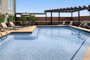 a swimming pool with a patio with chairs and tables at Fairfield Inn & Suites Nashville Near Vanderbilt in Nashville