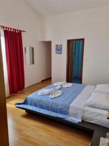 Cama grande en habitación con cortinas rojas en Bed and Breakfast MIRAMAR, en Starigrad-Paklenica