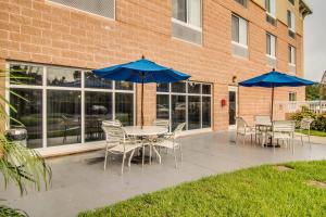 a table and chairs with umbrellas in front of a building at Fairfield Inn & Suites Palm Coast I-95 in Palm Coast