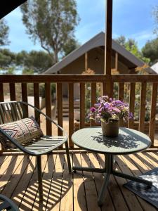 una mesa de patio y sillas en una terraza con flores en Camping Rodas en Rosas