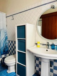 La salle de bains est pourvue d'un lavabo, de toilettes et d'un miroir. dans l'établissement Pietre Nere House, à Pozzallo