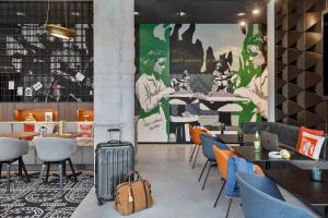 a restaurant with tables and chairs with a suitcase at Moxy Kaunas Center in Kaunas