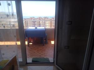 a room with a table and a balcony with a view at Lindita's Seaview Appartment in Vlorë