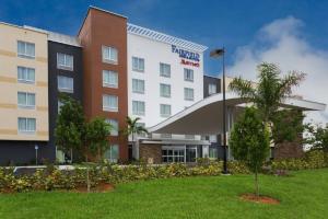 a hotel building with a palm tree in front of it at Fairfield Inn & Suites by Marriott Fort Lauderdale Pembroke Pines in Pembroke Pines