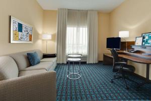 uma sala de estar com um sofá e uma secretária num quarto de hotel em Fairfield Inn & Suites by Marriott Fort Lauderdale Pembroke Pines em Pembroke Pines