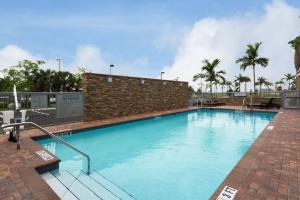 een groot blauw zwembad met een bakstenen muur bij Fairfield Inn & Suites by Marriott Fort Lauderdale Pembroke Pines in Pembroke Pines