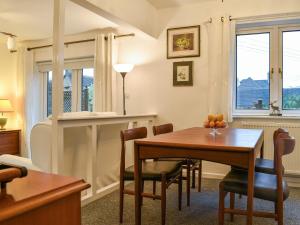 a dining room with a table and chairs and a window at The Churn in Bisley