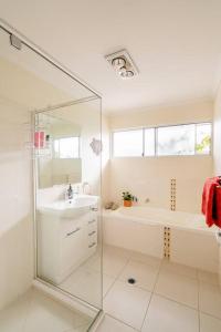 a bathroom with a shower and a sink and a tub at Cosy Home in Yandina in Yandina