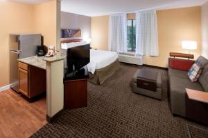 a hotel room with a bed and a television at TownePlace Suites Dallas Las Colinas in Irving