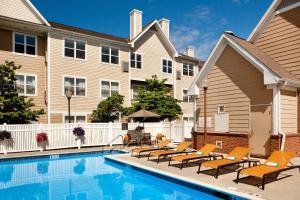 a swimming pool with lounge chairs next to a building at Residence Inn Hartford Manchester in Manchester