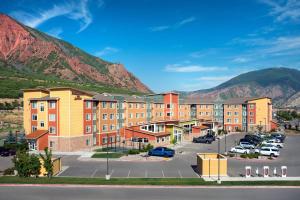 a building with a parking lot with mountains in the background at Residence Inn Glenwood Springs in Glenwood Springs