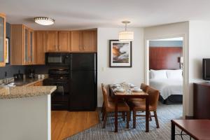 cocina y comedor con mesa y cama en Residence Inn Glenwood Springs, en Glenwood Springs