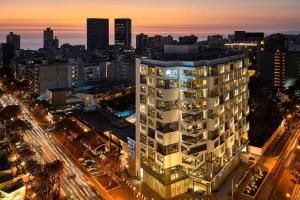 Ein hohes weißes Gebäude in der Nacht in der Unterkunft Aloft Lima Miraflores in Lima