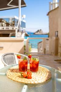 two drinks on a table with strawberries on it at Pargabella apartments in Parga