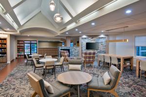 a library with tables and chairs and a tv at Residence Inn by Marriott Boston Brockton/Easton in Brockton
