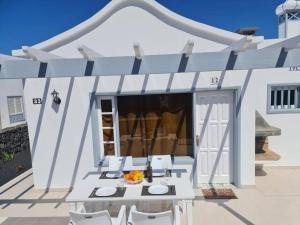 a white pergola with a table and chairs on a patio at Villa Toledo in Tías