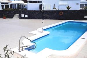 a swimming pool with a chair next to a house at Villa Toledo in Tías