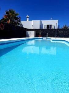 a large blue swimming pool in front of a house at Villa Toledo in Tías