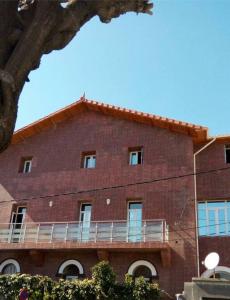 a large red brick building with a balcony at Ghazalle Oasis Hotel 1 in El Biar