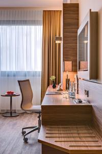 ein Büro mit einem Schreibtisch, einem Stuhl und einem Fenster in der Unterkunft Bonn Marriott Hotel in Bonn
