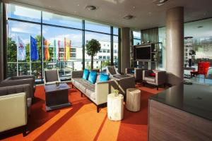 a living room with a couch and a large window at Bonn Marriott Hotel in Bonn