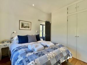 1 dormitorio con 1 cama con manta azul y blanca en Primrose Lodge en Mayfield