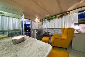 1 dormitorio con 1 cama y 1 silla amarilla en HouseBoat Isurus Quinto en Puerto Calero