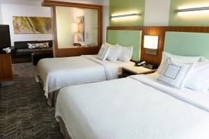 a hotel room with two beds and a couch at SpringHill Suites by Marriott Sioux Falls in Sioux Falls