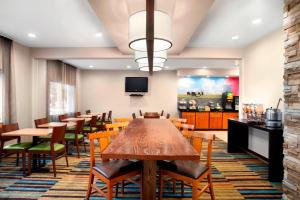 a dining room with tables and chairs and a tv at Fairfield Inn by Marriott Dubuque in Dubuque