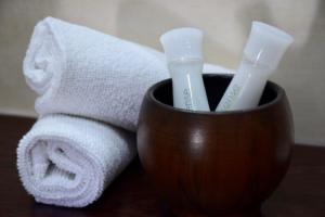 a brown cup with two toothbrushes and towels at Hotel Lotus in Hermina-major