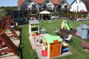 un patio de juguetes con equipo de juego y una casa en Willa Klif, en Rowy