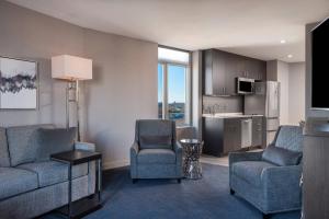 a living room with a couch and chairs and a kitchen at Residence Inn Boston Downtown/South End in Boston