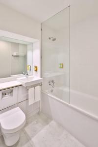 een witte badkamer met een toilet, een wastafel en een douche bij Fairfield by Marriott Bengaluru Whitefield in Bangalore