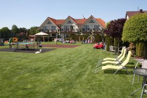a yard with chairs and a playground in front of a house at Willa Klif in Rowy +64 photos