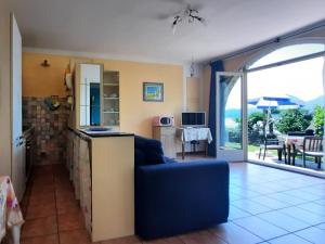 a living room with a blue couch and a kitchen at Appartamento Porto 1 in Cannero Riviera