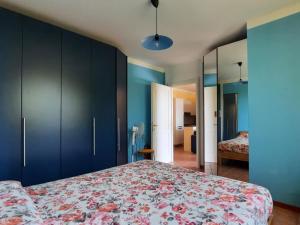 Schlafzimmer mit einem großen Bett und blauen Schränken in der Unterkunft Appartamento Porto 1 in Cannero Riviera