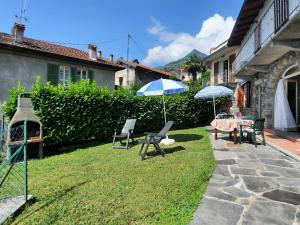 - une terrasse avec 2 parasols, une table et des chaises dans l'établissement Appartamento Porto 1, à Cannero Riviera