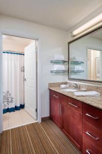 a bathroom with a sink and a mirror and a shower at Residence Inn by Marriott Cedar Rapids in Cedar Rapids