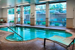 ein großer Pool in einem Gebäude mit Fenstern in der Unterkunft SpringHill Suites by Marriott Lake Charles in Lake Charles