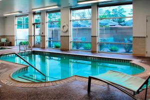 a large swimming pool in a building with windows at SpringHill Suites by Marriott Lake Charles in Lake Charles