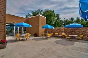 eine Terrasse mit Tischen, Stühlen und blauen Sonnenschirmen in der Unterkunft Fairfield Inn & Suites by Marriott Towanda Wysox in Towanda