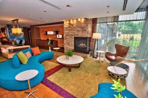 a living room with a blue couch and a fireplace at Fairfield Inn & Suites by Marriott Towanda Wysox in Towanda