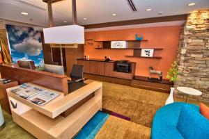 a hotel lobby with a reception desk and a blue couch at Fairfield Inn & Suites by Marriott Towanda Wysox in Towanda